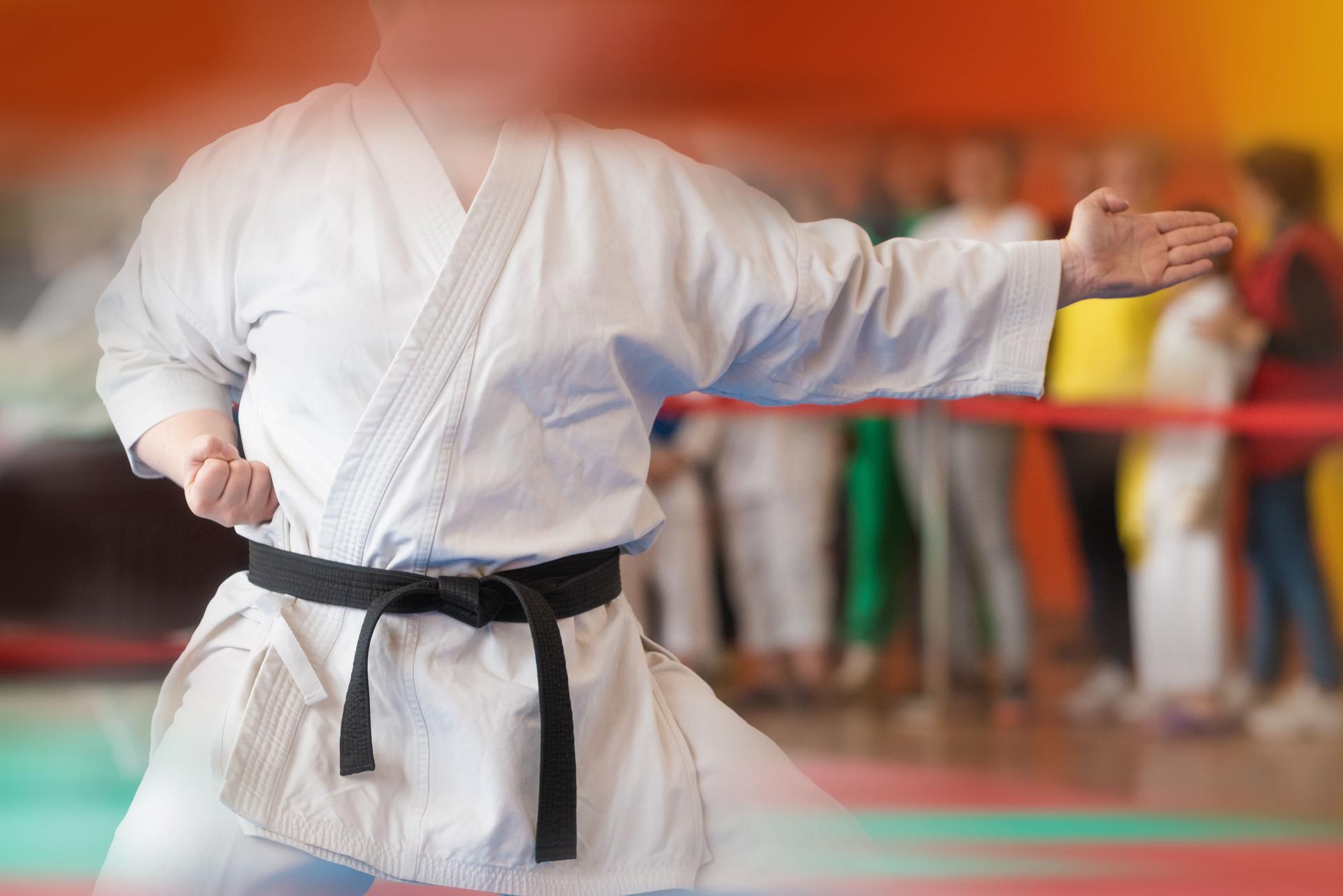 Combat sports background with motion blur and athletes silhouettes.